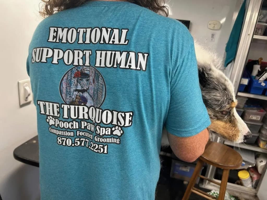Emotional Support Human comforting a pet during grooming at Turquoise Pooch Paw Spa